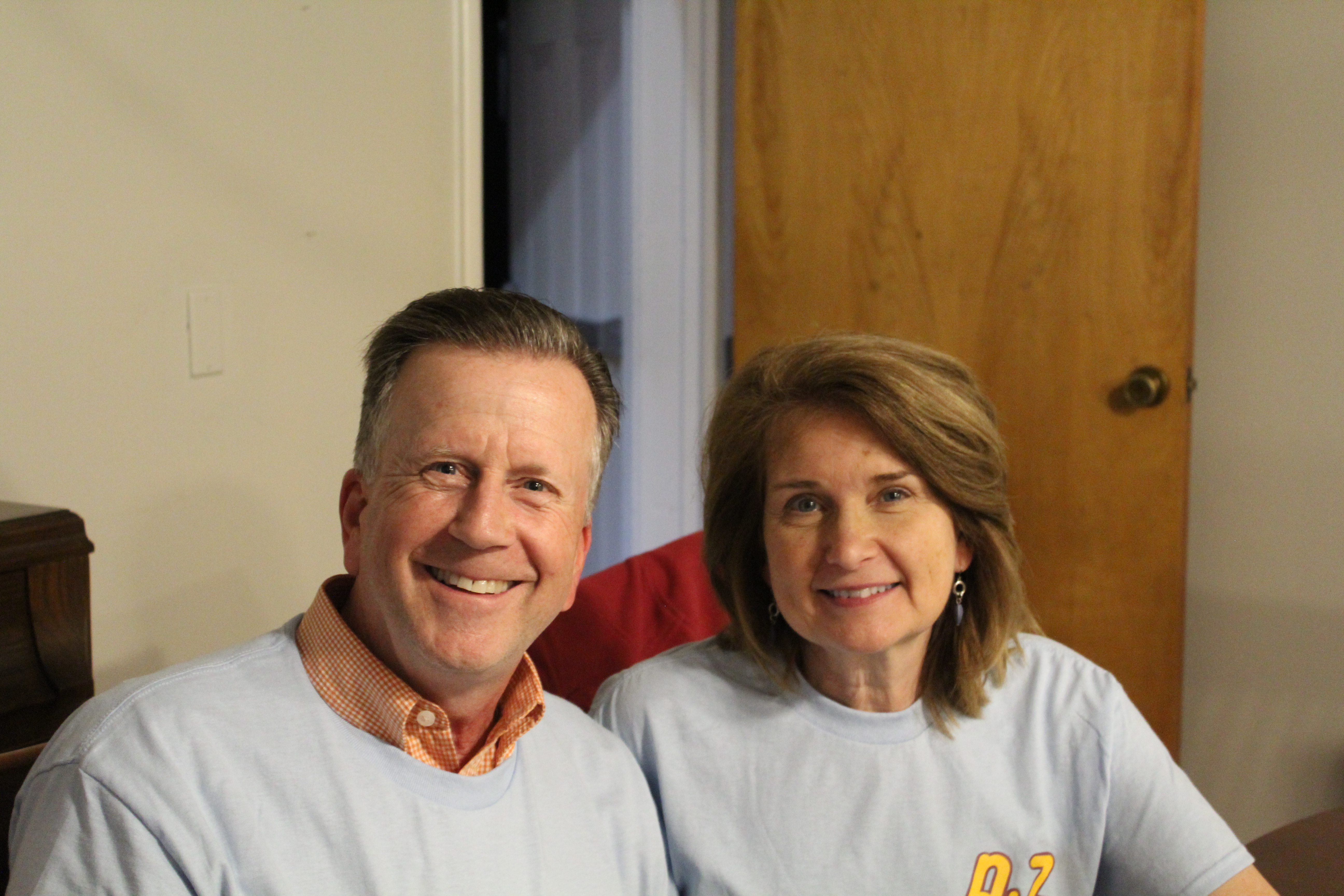 A couple wearing “Grilled Cheesy with the Dee Zees” tshirts while eating in the sorority’s dining room.